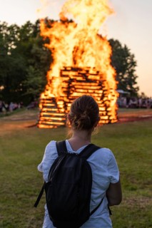 Woman in front of the midsummer fire in the Lenninger Valley on 21/06/2025