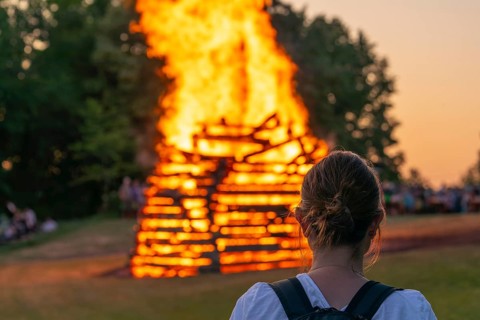 Woman in front of the midsummer fire in the Lenninger Valley on 21/06/2025