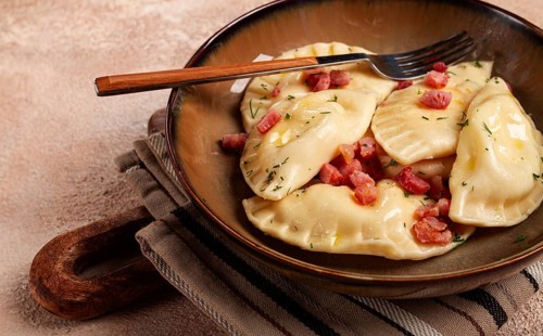 Dumplings, with fried prosciutto, a traditional dish of Polish cuisine, dumplings, top view,