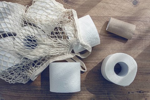 Mesh bag on the table, with rolls of toilet paper, top view, no people