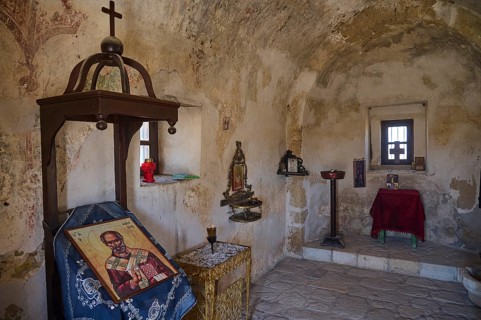 Interior view of a small chapel with icons and religious symbols on the wall, Agios Nikolaos