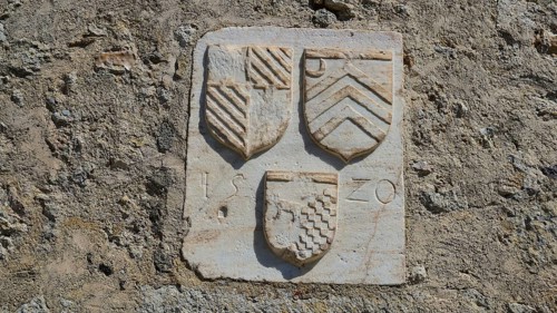 Coat of arms of the Grand Master del Carretto, close-up of stone coat of arms on a historic wall,