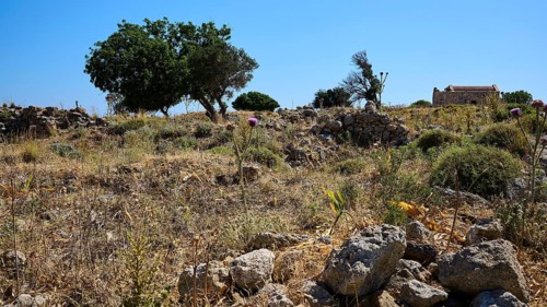 Mediterranean landscape with cairns, vegetation and trees under a clear sky, Agios Nikolaos Chapel,