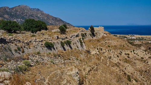 Rocky ruins on a coastal landscape with sea and sunny sky, Kardamina, Antimacheia, Medieval
