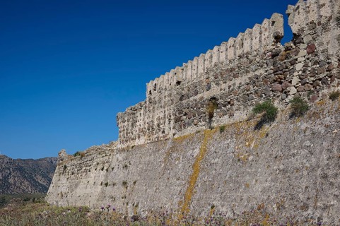 Defence wall, Outer wall, Extensive stone fortifications with vegetation under blue sky,