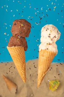 Chocolate and vanilla ice cream in wafers against a blue background with sprinkles