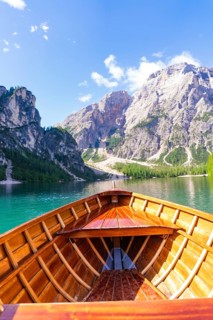 Perspective from the boat towards the majestic mountain landscape over clear water, Pragser