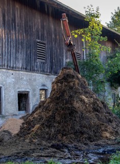 Highest dung heap in front of an old barn, surrounded by rural idyll, Bavaria, Germany
