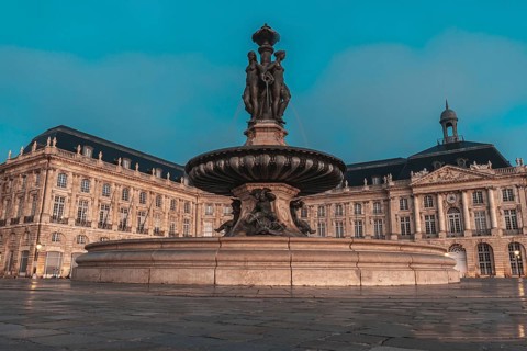 The fountain of the three graces graces place de la bourse in bordeaux, france, illuminated by the