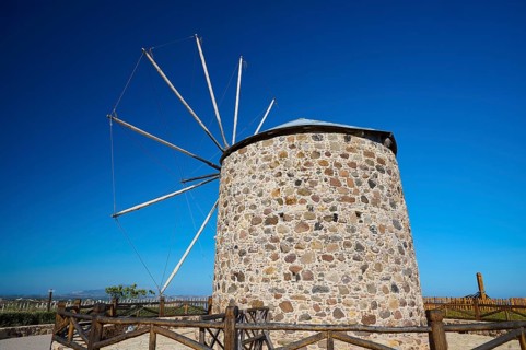 Stone windmill with wooden railings under a blue sky, Kefalos, Kos, Dodecanese, Greek Islands,