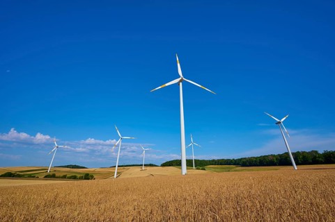 Wind turbines overlook a wide field under a clear blue sky, summer, Wenkheim, Werbach,