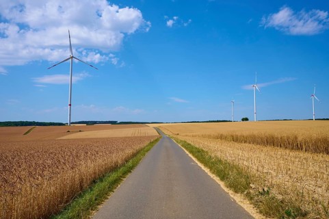 Several wind turbines above golden cornfields under a clear summer sky, summer, Retzstadt, Main