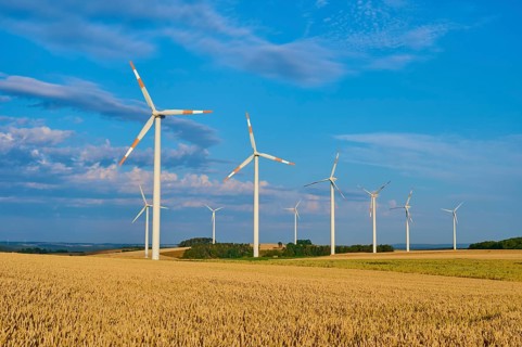 A wind farm on wide fields with several wind turbines under a blue sky, summer, Höhefeld, Wertheim,