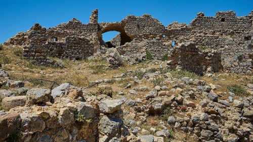 A vast field of ruins with brick arches under a bright blue sky, Abandoned Village, Lost Place,