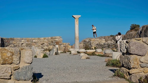 Ancient ruins with a medium-sized column and blue sky in the background, Agios Stefanos Beach,