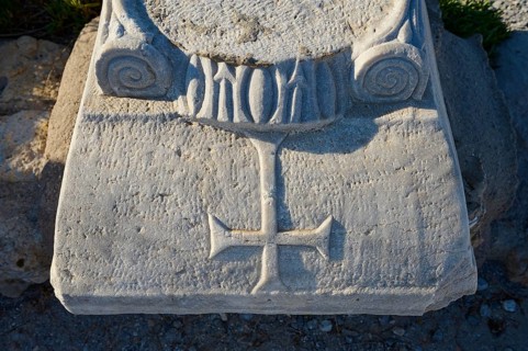 Detail of a stone pedestal with engraved cross and decorations, Agios Stefanos Beach, Agios