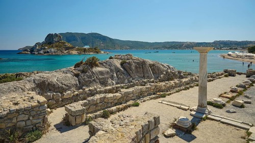 Ruins with a view of an island in the background, bright blue sea, Agios Stefanos Beach, Agios