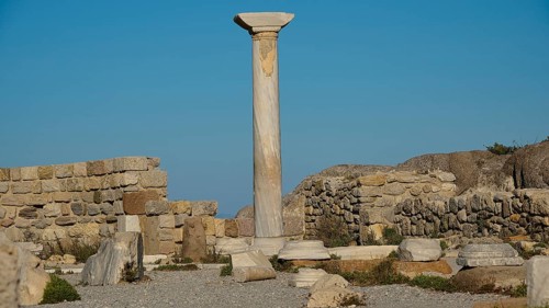 Ruins with a towering ancient column against a clear sky, Agios Stefanos Beach, Agios Stefanos