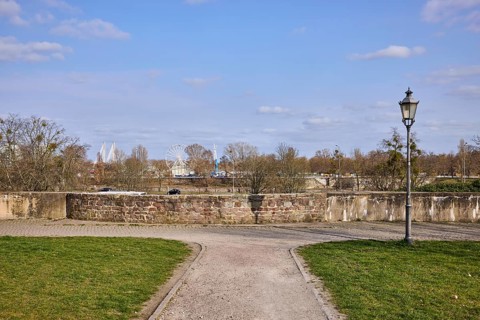Park, lantern, city fortification, city wall, bare wintry trees, blue sky, cumulus clouds,