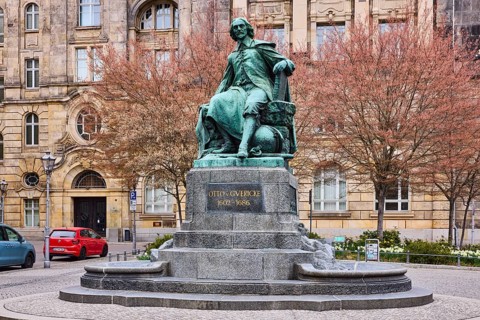Monument to Otto von Guericke, sandstone building, public order office, bare winter trees, parking