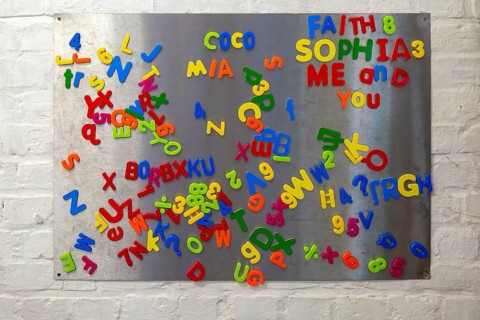 Plastic colourful magnetic letters and numbers on metal board, UK