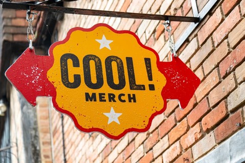 Cool! Merch shop sign fixed to wall, Salisbury, Wiltshire, England, UK