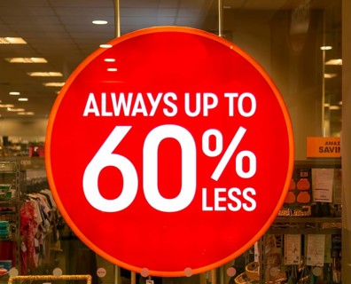 Always up to 60% less sale sign in TK Maxx shop window, Wiltshire, England, UK