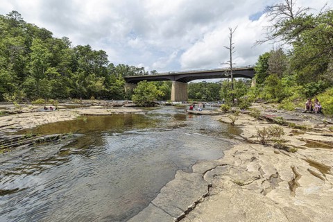 People playing on the rocks under the Little River Falls Bridge in Little River Canyon Falls Park