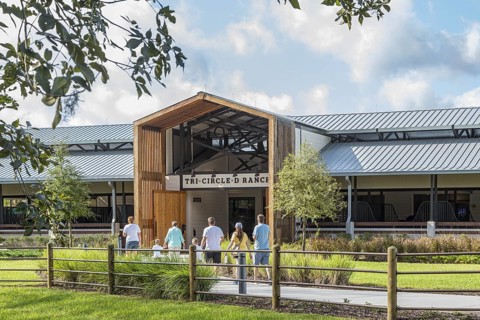 Family entering the Tri-Circle-D Ranch horse stables in the Fort Wilderness Campground and Resort