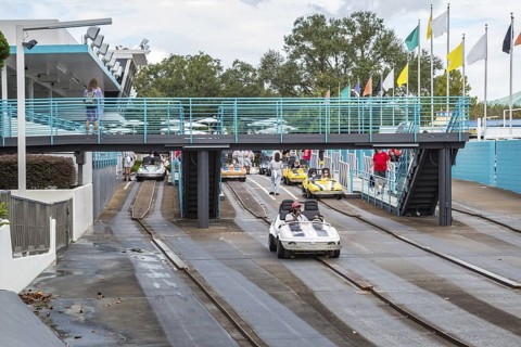 Black man and son riding a car in the Tomorrowland Speedway at the Tomorrow land area of the Magic