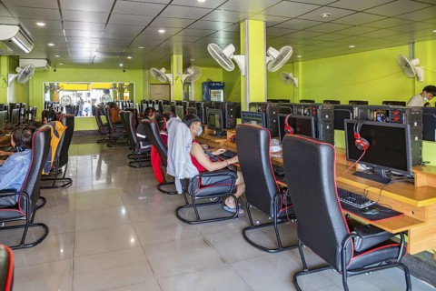 Thai men and boys playing games online at an Internet gaming business in Chiang Rai, Thailand