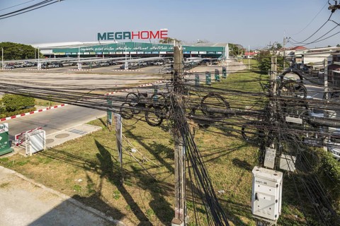 Tangled mess of utility wires in front of the Mega Home Center building materials store in Chiang