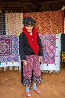 Traditionally dressed woman selling hand woven items in the Lu Mien-Yao tribe area of the Union of