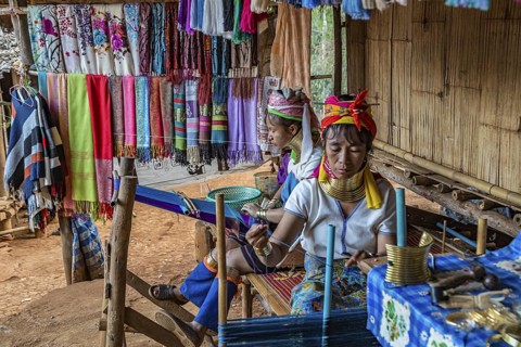 Tribal women weaving scarves to be sold in the Long Neck Karen tribe (more properly called the