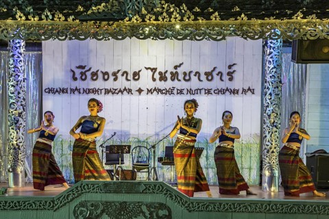 Traditional Thai dancers perform on a lighted stage at the night market in downtown Chiang Rai,