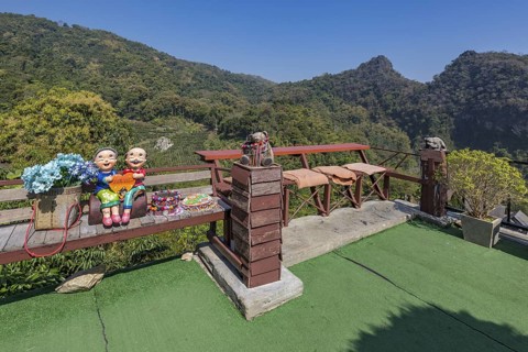 Ceramic statue of Thai couple holding a heart on a bench at the Doi Phamee coffee shop and