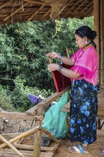 Woman weaving items to sell at the Union of Hill Tribe Villages outside of Chiang Rai in the