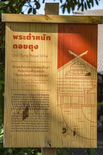 Wooden sign in Thai and English describes the Doi Tung Royal Villa inside the Doi Tung tourist