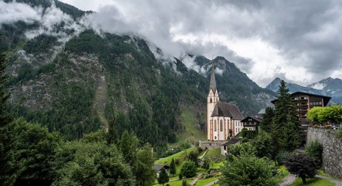 Parish church of St Vincent in Heiligenblut, cloudy mountain landscape, courtyard, Heiligenblut am