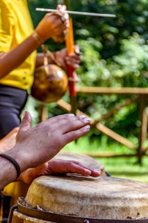 Hands of musicians playing berimbau and atabaque in Brazilian capoeira outdoors, Minas Gerais,