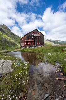 Elberfelderhütte mountain hut with small lake and cotton grass, in the upper Gössnitz valley,