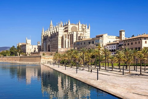 View at the famous Palma Cathedral with reflections in the water a sunny summer day, Palma de