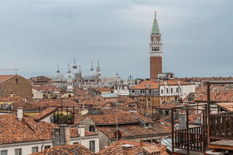 Red tiled roofs, chimneys and church domes dominate the venetian skyline with saint marks campanile