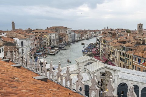 Gondolas navigating the grand canal amidst historic buildings in venice, italy, seen from a rooftop