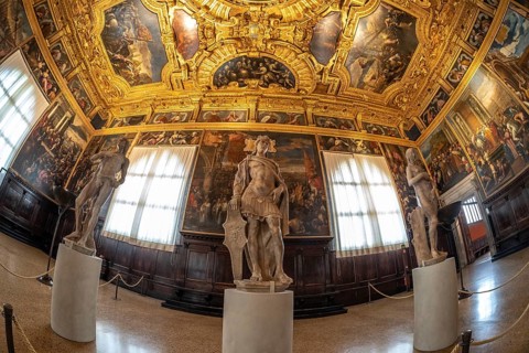 Classical sculptures stand amidst the grandeur of a richly decorated hall within doge's palace,