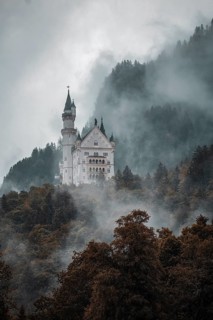 The mystical Neuschwanstein Castle in the dense fog of the mountains, Schwangau, Bavaria