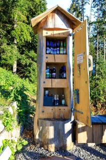 Tree trunk as a cupboard filled with drinks bottles at the Bollenbacher Bierbänkle, Haslach im