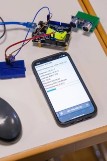 Smartphone on table next to electronic devices, displays measured values, Nagold Youth Research