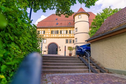 Half-timbered house with courtyard, stairs and parked car, surrounded by trees, Deufringen,