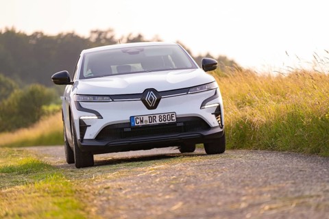 White car driving along a rural road next to a field, Renault Megane, Deer E Carsharing, electric